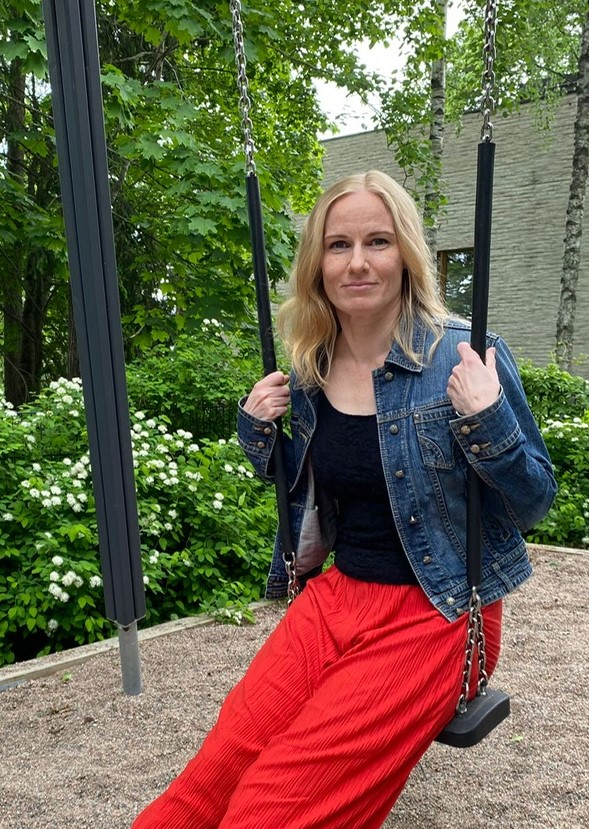 man and woman laughing while sitting in front of laptops